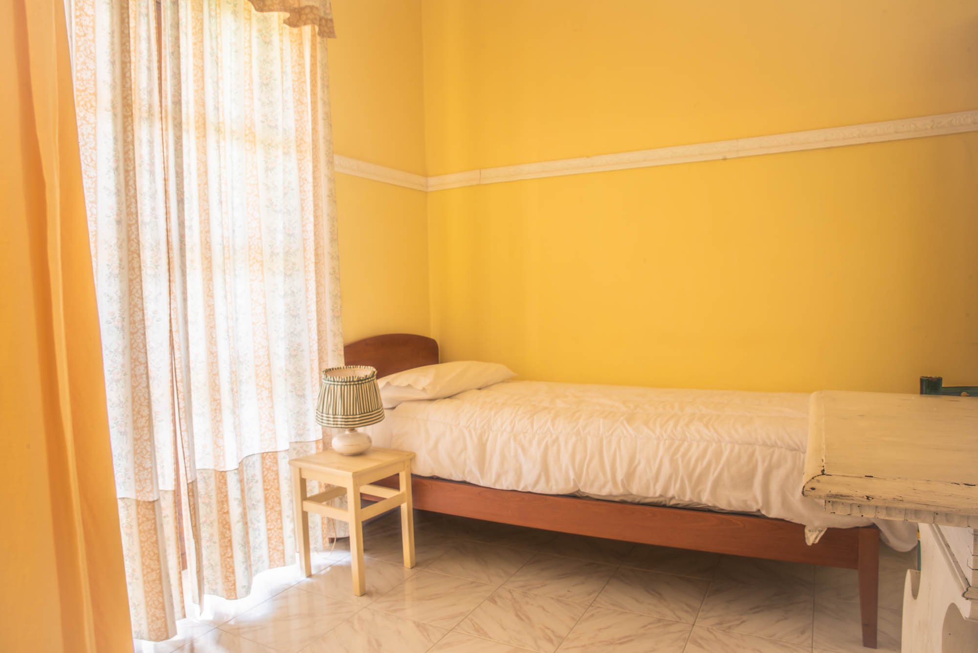 stanza di agriturismo con letto singolo e pareti gialle